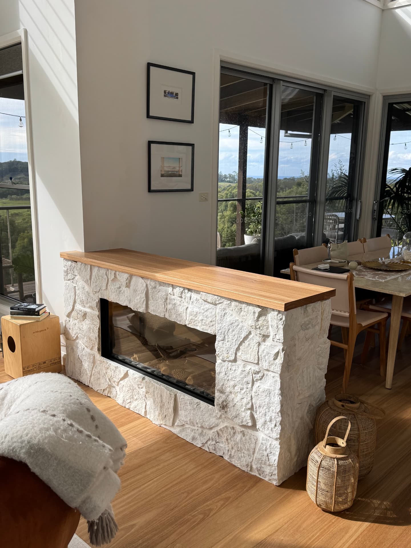 Double-sided sandstone fireplace with a thick timber mantel
